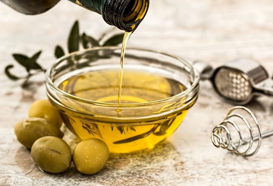 pouring poil into a bowl with olives
