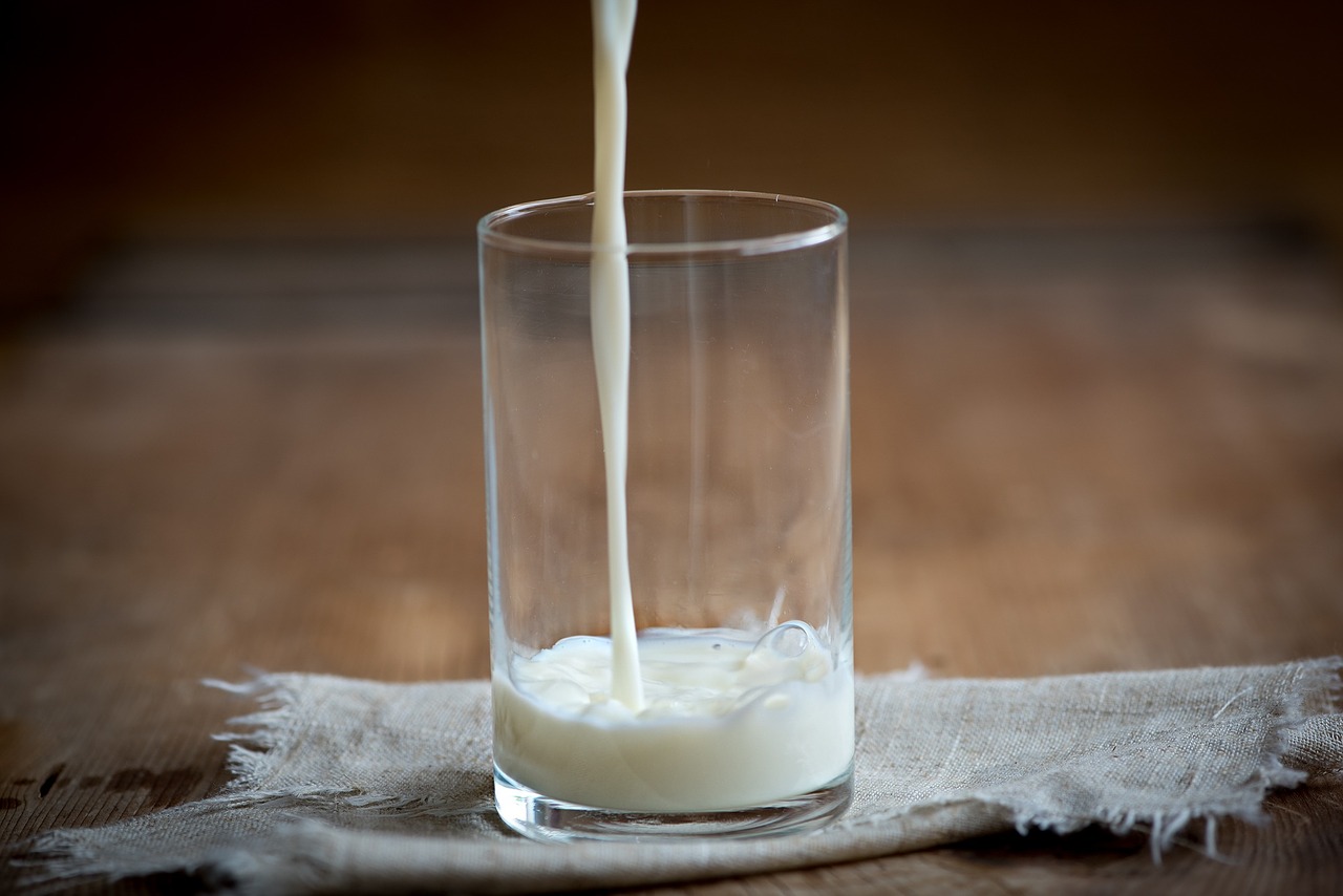 milk poring into glass milk being poured into a glass
