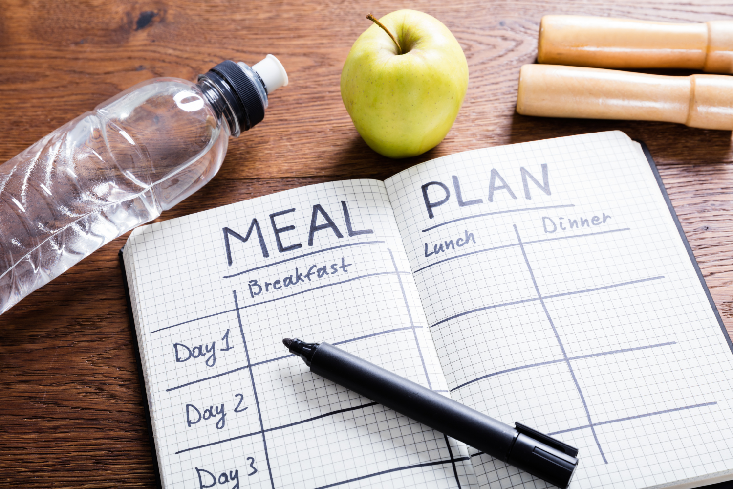 Meal planning book and bottle and apple An empty meal plan