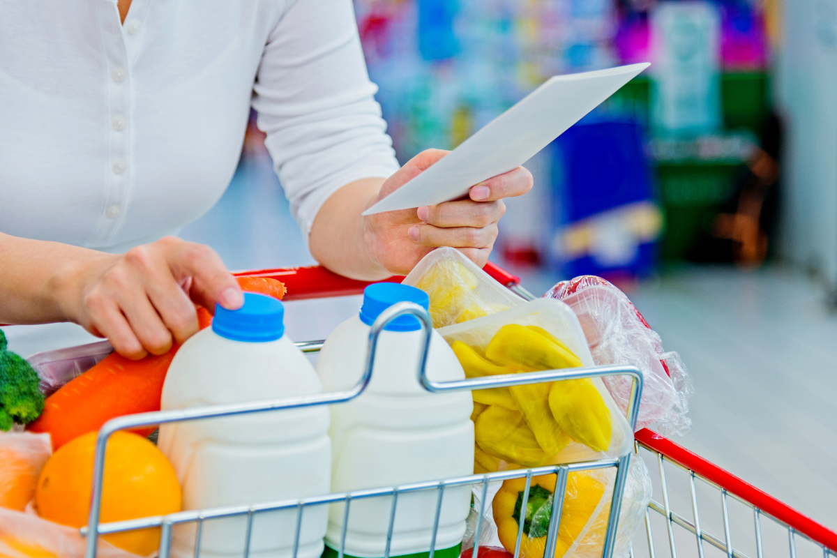 shopping with shopping list picture of person in store with a trolley and a shopping list